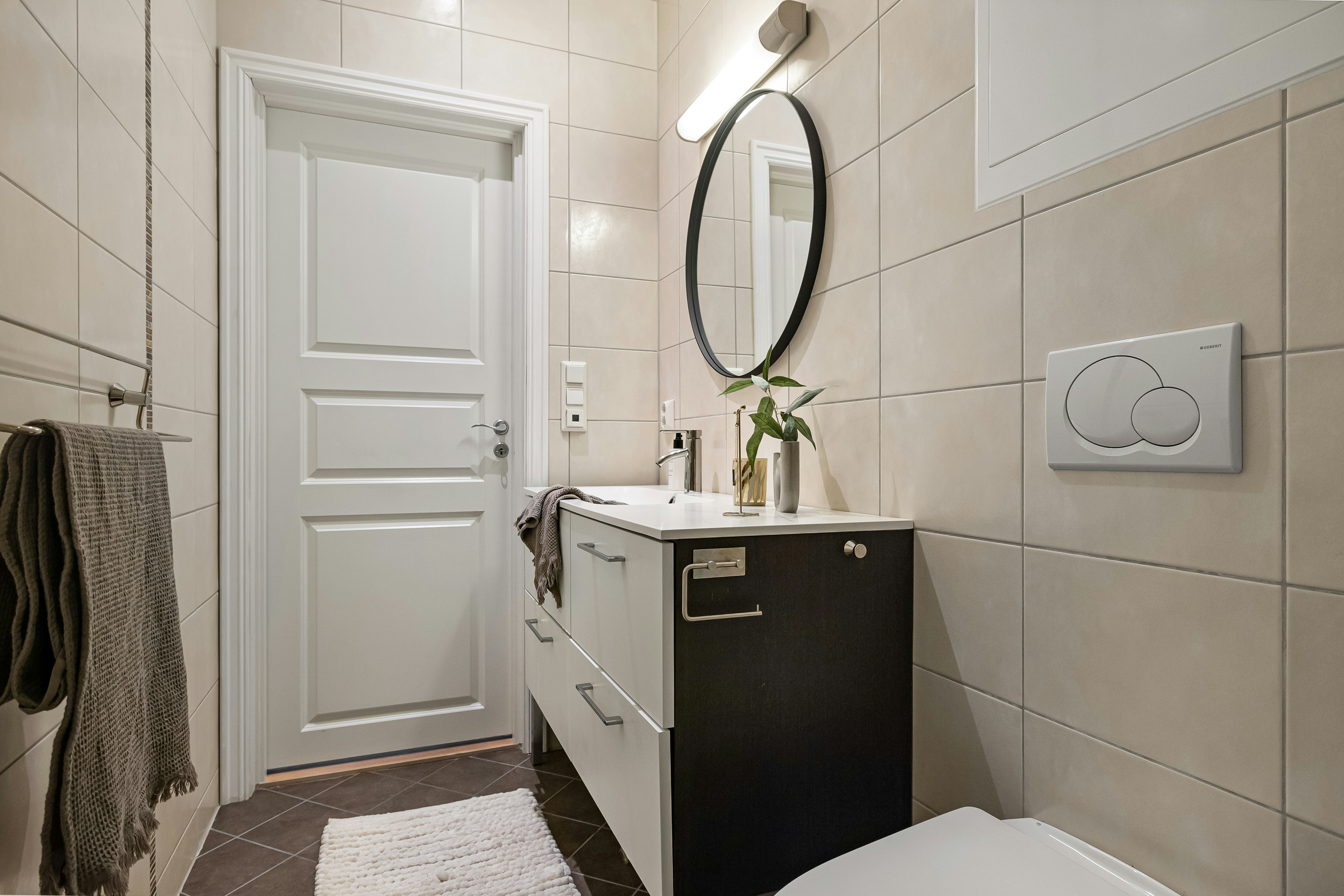 A bathroom with a toilet, sink and mirror